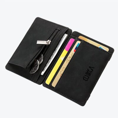 Portefeuille noir ouvert en grand avec des cartes à l'intérieur et des pièces de monnaie qui sorte de la poche sur la gauche.