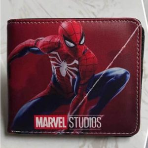 Ce portefeuille est rouge et rectangulaire avec un dessin de spider-man. Il est posé sur un fond en marbre.