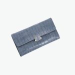 Grand portefeuille bleu aspect crocodile et fermoir doré.