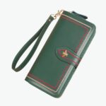 Grand portefeuille en cuir vert avec fermoir en abeille doré et fil rouge cousu sur les coutures.