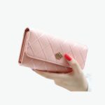 Grand portefeuille rose en cuir synthétique avec symbole couronne.