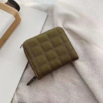 Mini portefeuille matelassé vert kaki posé sur du tissu