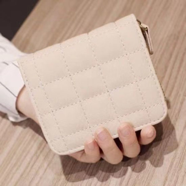 Mini portefeuille matelassé beige tenue par une main