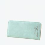 Joli chéquier porte feuille, porte chéquier en cuir synthétique vert d'eau à la grande capacité pour contenir tous vos papiers. Il est posé sur une table près d'un bouquet de fleurs et d'un cadre photo.