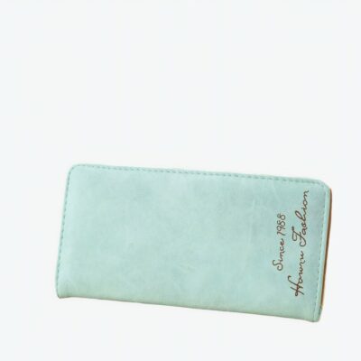 Joli chéquier porte feuille, porte chéquier en cuir synthétique vert d'eau à la grande capacité pour contenir tous vos papiers. Il est posé sur une table près d'un bouquet de fleurs et d'un cadre photo.