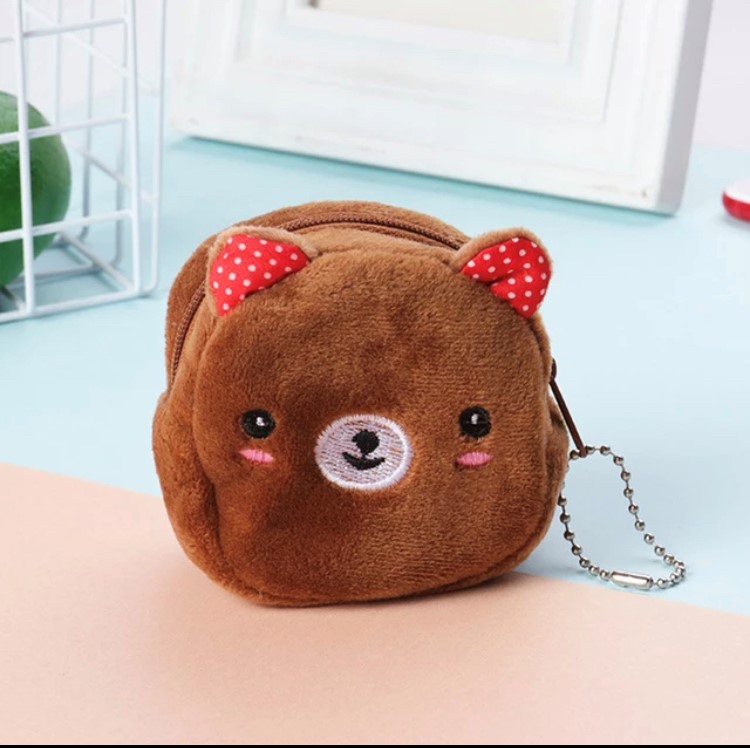 Petit porte-monnaie en peluche pour enfant représentant la tête d'un ourson avec des oreilles rouges.