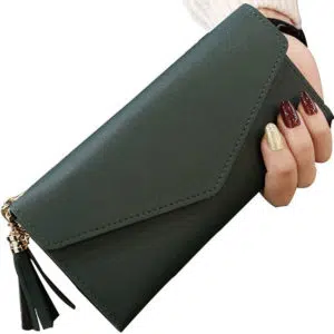 Pochette portefeuille vert avec un pompon tenue dans une main