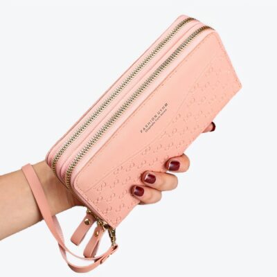 Portefeuille rose pâle tenu dans une main avec du vernis rouge