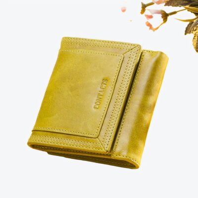 Portefeuille jaune en cuir sur fond jaune avec un quadrillage blanc et noir et des boutons de roses rose.