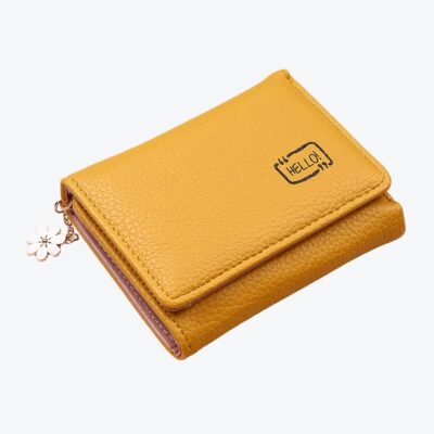 Portefeuille jaune avec un pendentif à fleur sur fond rose