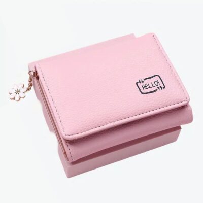 Portefeuille rose avec un pendentif à fleur sur fond rose